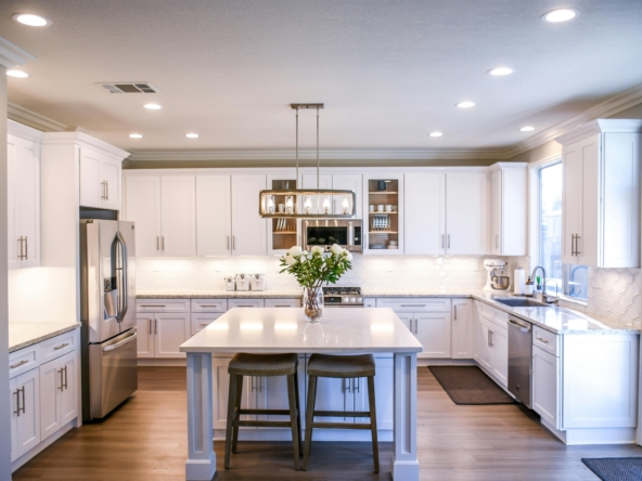 Spacious and elegant kitchen featuring white cabinetry, island, and stainless steel appliances.